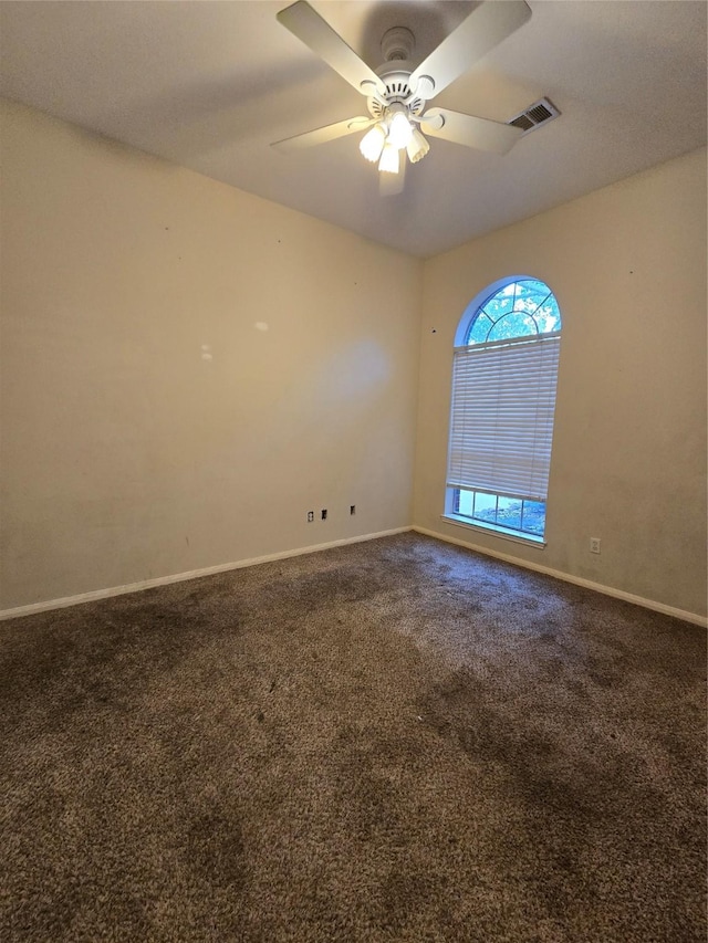 spare room featuring ceiling fan and carpet