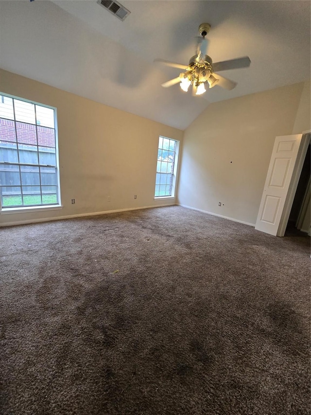 carpeted empty room with ceiling fan, a healthy amount of sunlight, and vaulted ceiling