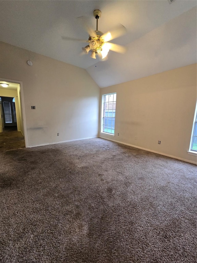 unfurnished room with ceiling fan, dark carpet, and vaulted ceiling