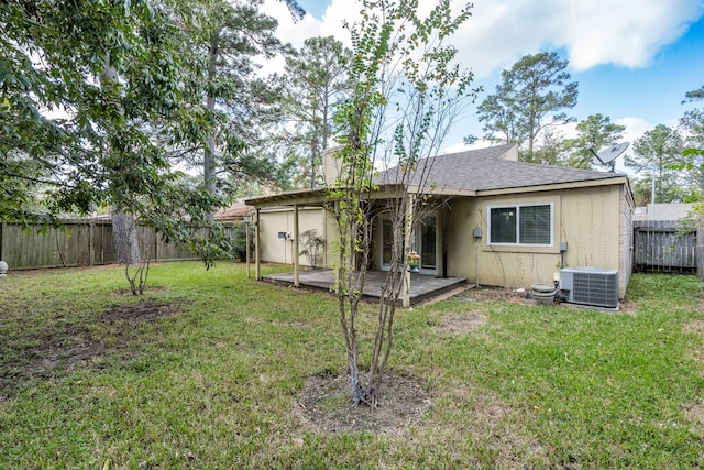 rear view of property with a patio, cooling unit, and a lawn