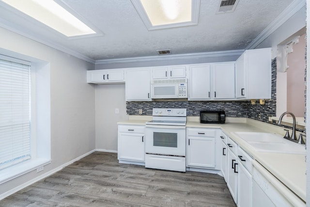 kitchen with sink, backsplash, a textured ceiling, white appliances, and white cabinets