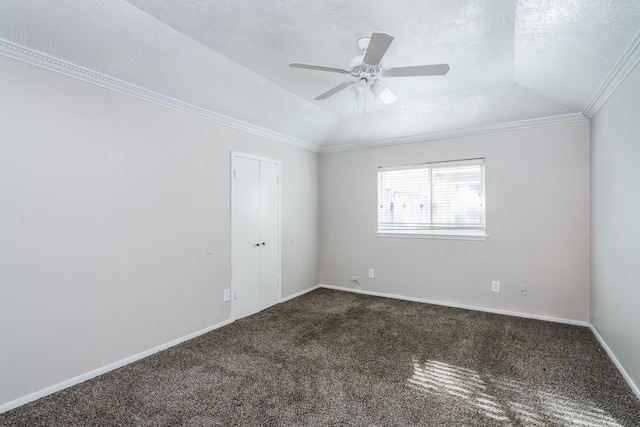 spare room with a textured ceiling, carpet floors, crown molding, and lofted ceiling