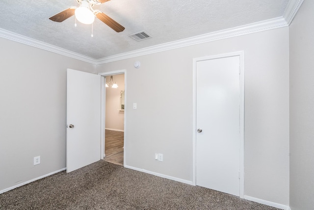 unfurnished bedroom with carpet, ceiling fan, ornamental molding, and a textured ceiling