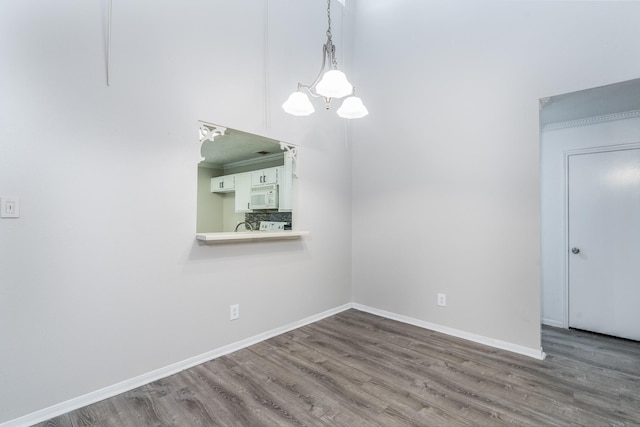 unfurnished dining area with hardwood / wood-style flooring and a notable chandelier