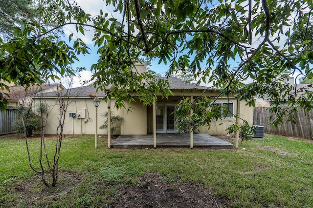 back of property with a lawn and central air condition unit