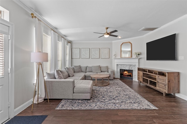 living room featuring ceiling fan, crown molding, and a premium fireplace