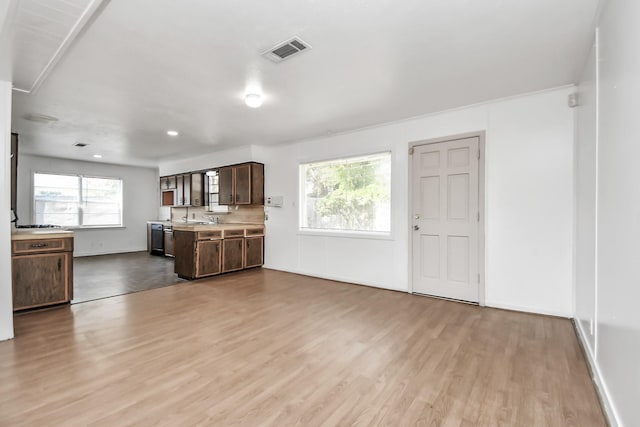 kitchen featuring dark brown cabinets, light hardwood / wood-style floors, sink, and dishwashing machine