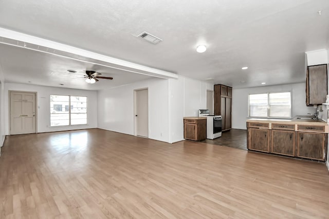 kitchen featuring a wealth of natural light, gas range gas stove, light hardwood / wood-style flooring, and ceiling fan