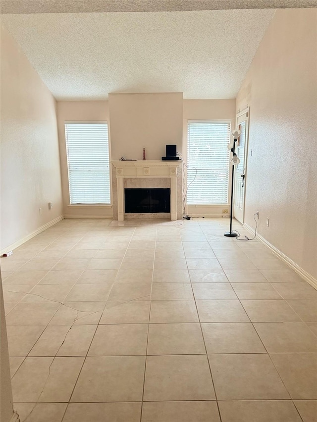 unfurnished living room with light tile patterned floors and a textured ceiling