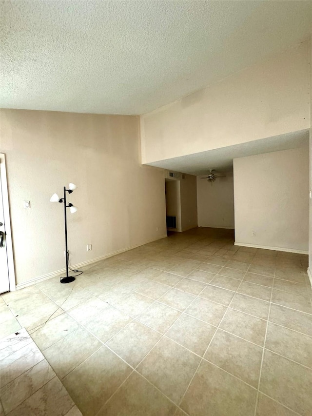 spare room with light tile patterned floors and a textured ceiling