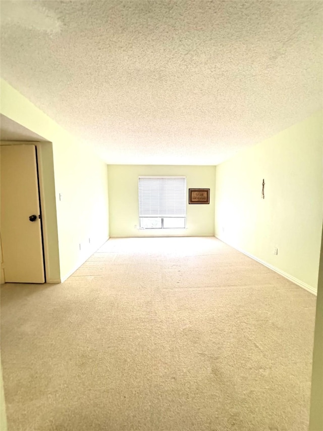 carpeted spare room with a textured ceiling