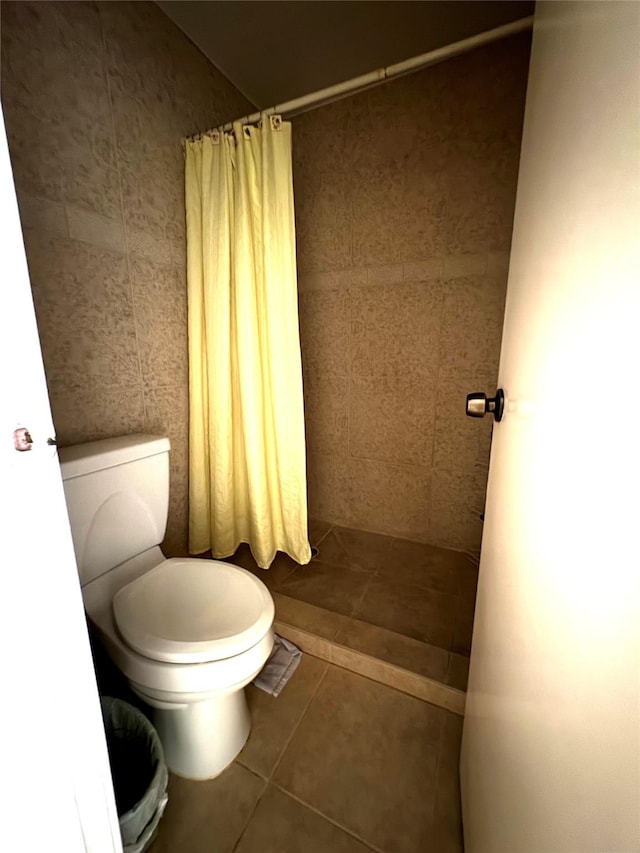 bathroom featuring toilet, tile patterned floors, and walk in shower