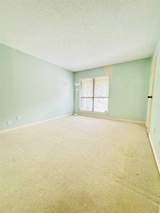 spare room with a textured ceiling and light carpet