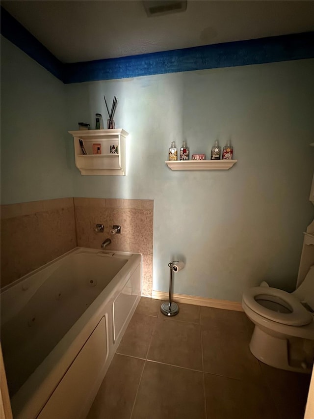 bathroom with tile patterned floors, a bathtub, and toilet