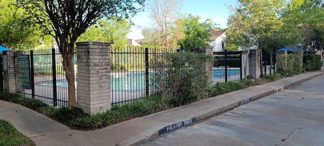 view of gate featuring a community pool