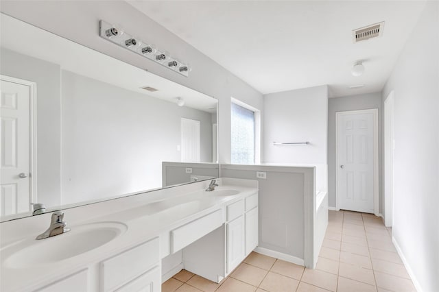 bathroom featuring tile patterned floors, tiled tub, and vanity