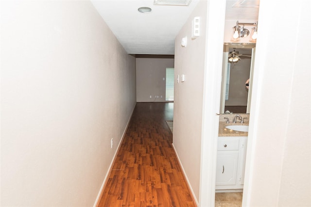 hall featuring dark hardwood / wood-style floors and sink