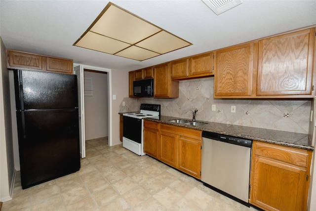 kitchen with sink, tasteful backsplash, dark stone countertops, and black appliances