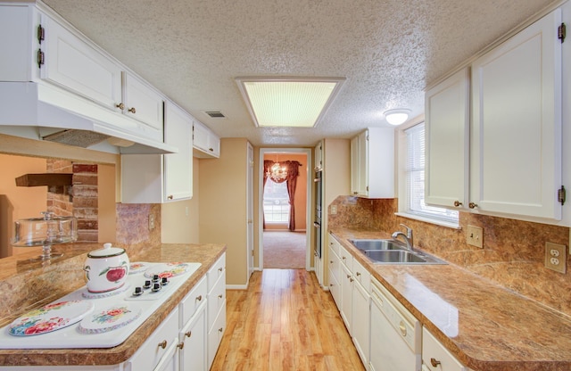 kitchen featuring white cabinets, white dishwasher, and sink