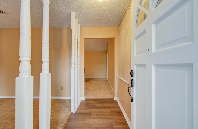 corridor featuring a textured ceiling and hardwood / wood-style flooring