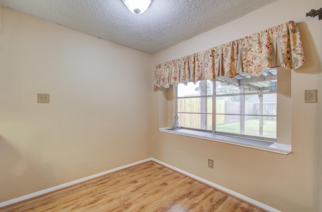 spare room with hardwood / wood-style flooring and a textured ceiling