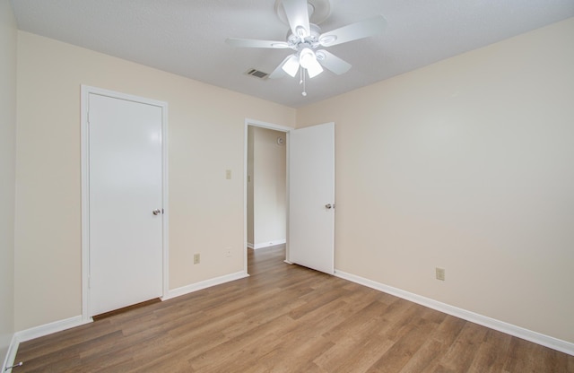 unfurnished bedroom with ceiling fan, a closet, and light hardwood / wood-style flooring