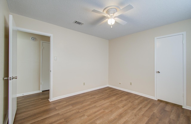 unfurnished bedroom with ceiling fan, light hardwood / wood-style flooring, and a textured ceiling