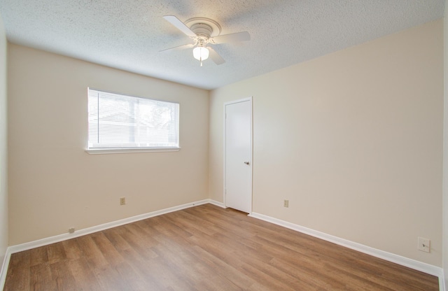 unfurnished room with ceiling fan, light wood-type flooring, and a textured ceiling