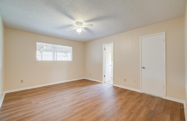 unfurnished room featuring ceiling fan, light wood-type flooring, and a textured ceiling