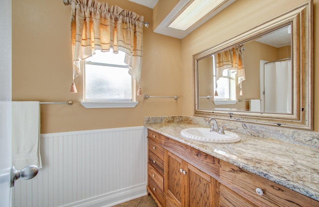 bathroom featuring tile patterned flooring, vanity, and a healthy amount of sunlight