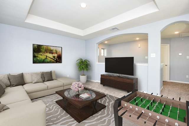 carpeted living room featuring a raised ceiling