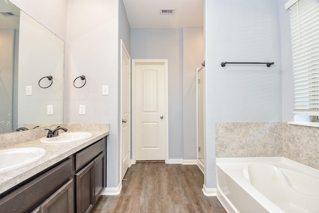 bathroom featuring a bath, vanity, and hardwood / wood-style floors