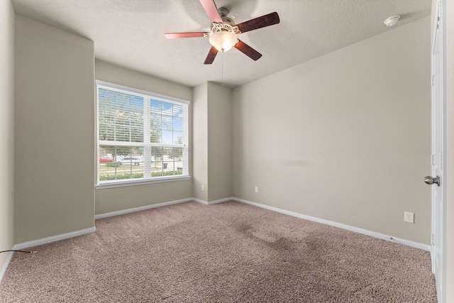 empty room with a textured ceiling, light colored carpet, and ceiling fan