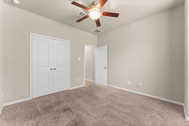 unfurnished bedroom with ceiling fan, carpet floors, and a closet