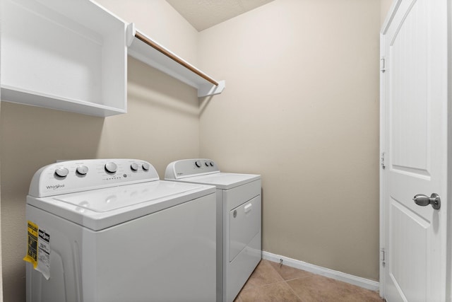 clothes washing area featuring washing machine and clothes dryer and light tile patterned floors