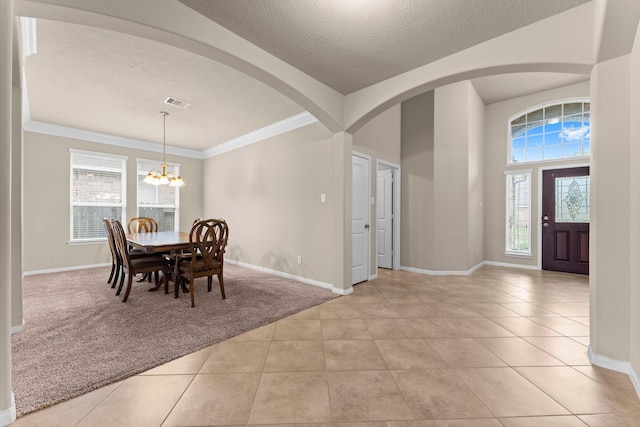 dining room featuring a chandelier, light tile patterned floors, plenty of natural light, and ornamental molding