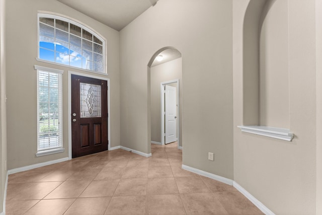 tiled entryway featuring a towering ceiling