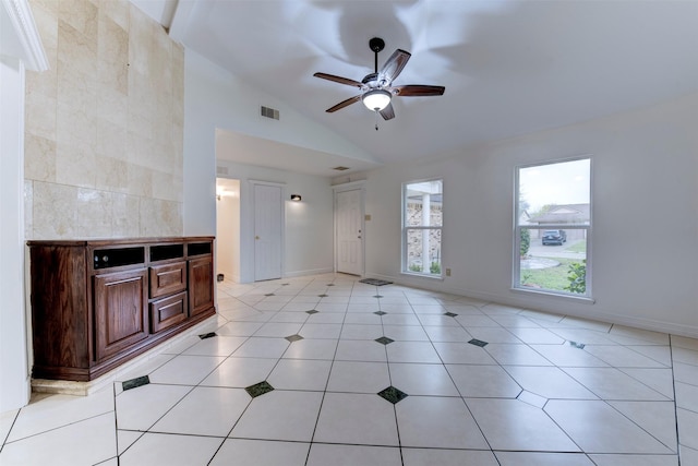 unfurnished living room featuring ceiling fan, light tile patterned floors, and vaulted ceiling