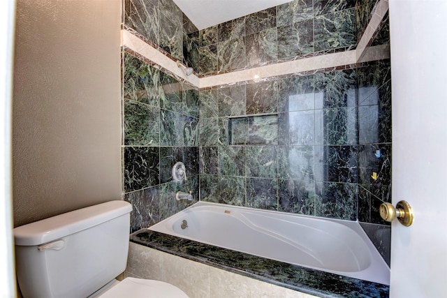 bathroom with tiled shower / bath combo and toilet