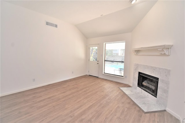 unfurnished living room featuring light wood-type flooring, lofted ceiling, and a fireplace