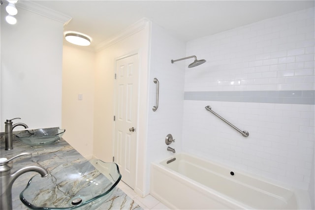 bathroom with tile patterned floors, tiled shower / bath, crown molding, and sink