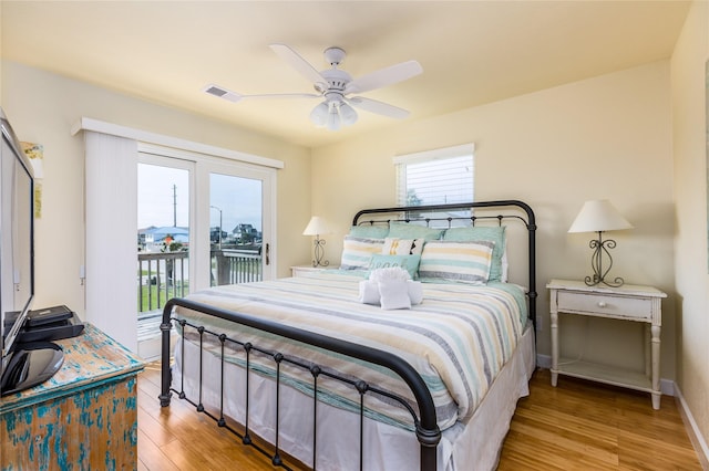 bedroom with access to exterior, ceiling fan, light hardwood / wood-style floors, and multiple windows