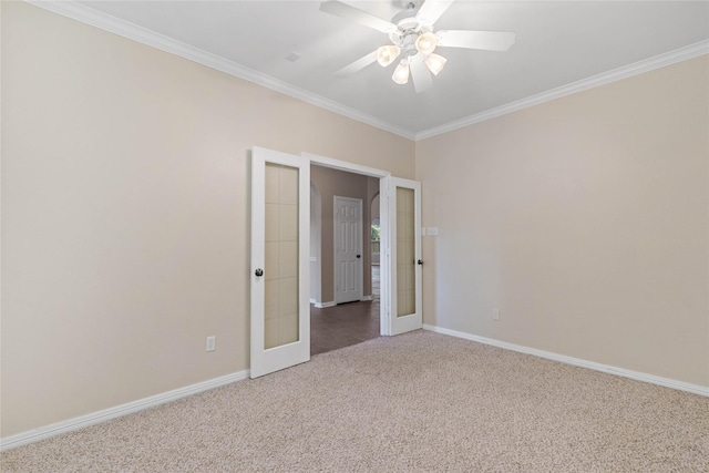 carpeted spare room featuring ceiling fan, crown molding, and french doors