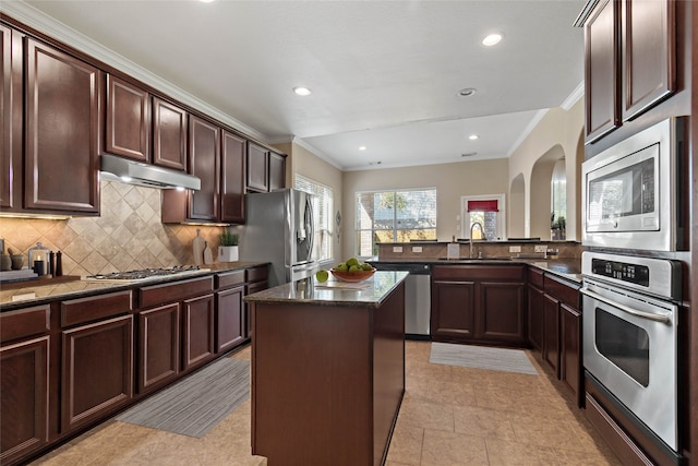 kitchen featuring backsplash, a center island, ornamental molding, and stainless steel appliances