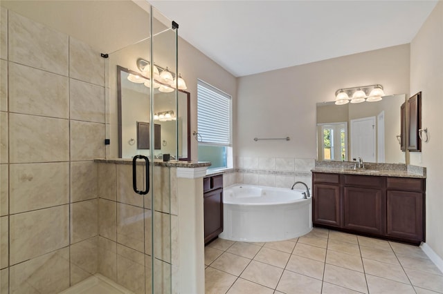 bathroom featuring plus walk in shower, vanity, and tile patterned flooring