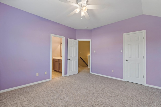 unfurnished bedroom with light carpet, ensuite bath, ceiling fan, and lofted ceiling