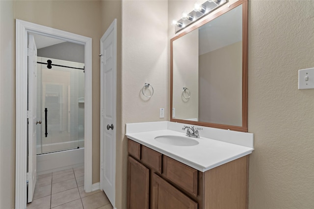 bathroom with tile patterned floors, vanity, and combined bath / shower with glass door