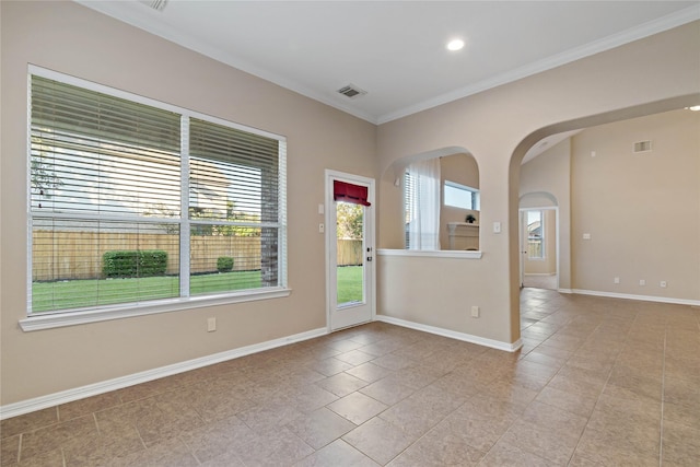 tiled spare room featuring crown molding