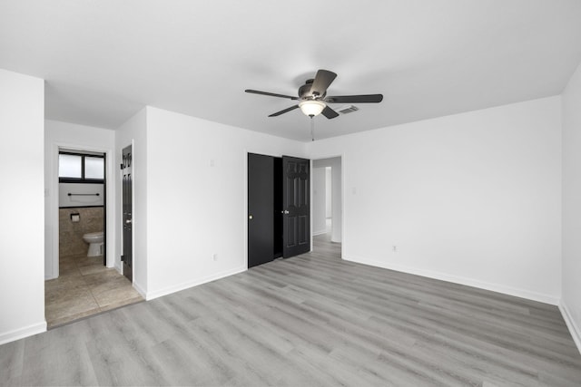 unfurnished bedroom with ceiling fan, light wood-type flooring, and ensuite bath