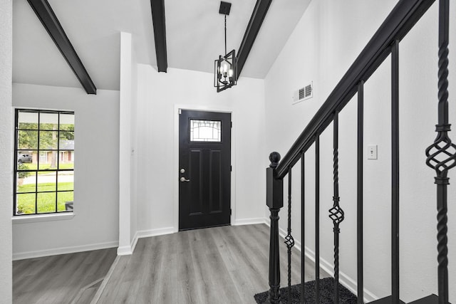 foyer with vaulted ceiling with beams, an inviting chandelier, and light hardwood / wood-style flooring